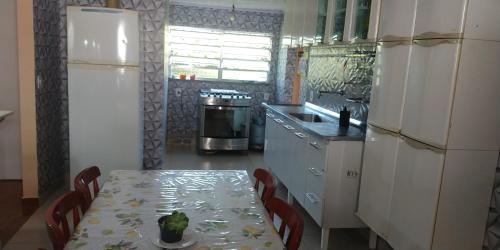a kitchen with a table with chairs and a refrigerator at Casa do Mirante in Petrópolis