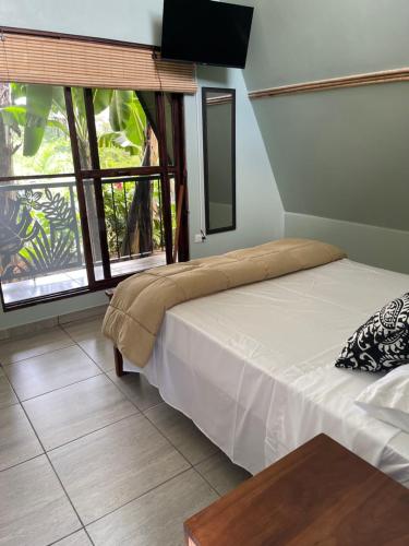 a bedroom with a bed and a large window at Las Casitas Italiana in Sabalito