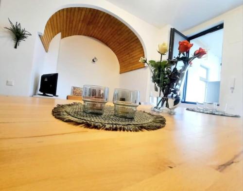 two glasses on a table with flowers in a room at Timisoara Central 2 Bedroom Hotel Serviced Belle Vue Apart By the Park in Timişoara
