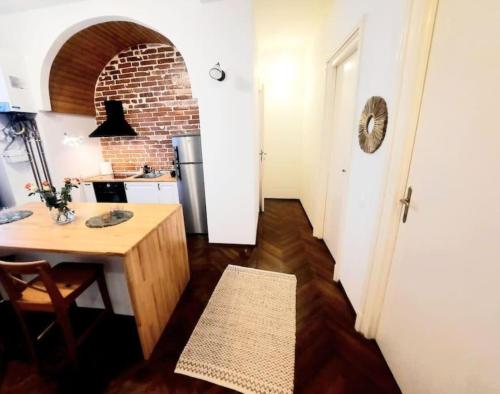 a kitchen with a table and a brick wall at Timisoara Central 2 Bedroom Hotel Serviced Belle Vue Apart By the Park in Timişoara