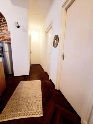 a hallway with a white door and a rug at Timisoara Central 2 Bedroom Hotel Serviced Belle Vue Apart By the Park in Timişoara