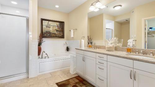 a bathroom with two sinks and a tub and a shower at Lake Travis Stunning Waterfront, Sunset & Pool Views, Pet Friendly, Boat Ramp, Lago Vista, Texas in Lago Vista