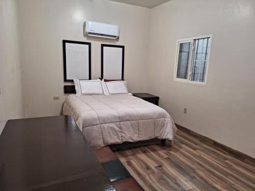 a bedroom with a bed with two pillows on it at MercedesHouse in Hermosillo