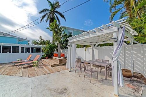a patio with a table and chairs and a pergola at Walk to the beach - Island Villa in Siesta Key