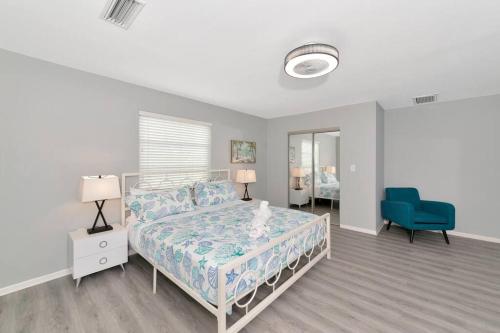 a bedroom with a bed and a blue chair at Walk to the beach - Island Villa in Siesta Key
