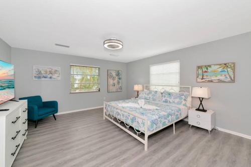 ein Schlafzimmer mit einem Bett und einem blauen Stuhl in der Unterkunft Walk to the beach - Island Villa in Siesta Key