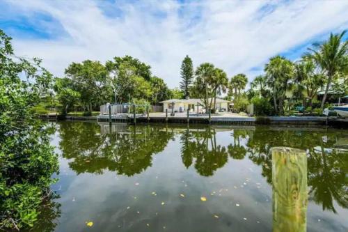 a pond with trees and a house in the background at Walk to the beach - Island Villa in Siesta Key