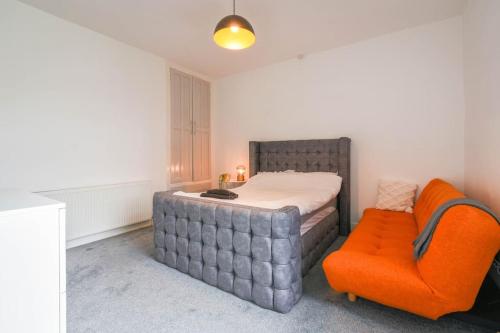 a bedroom with a bed and an orange chair at Home in the Heart of Accrington in Church