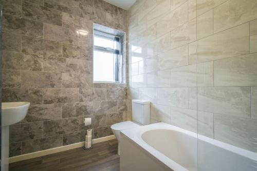 a bathroom with a tub and a sink at Home in the Heart of Accrington in Church