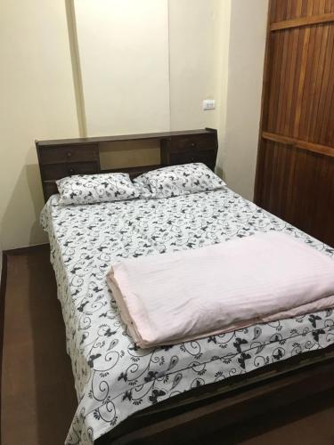 a bed with a black and white comforter at Albergue Camry Backpackers佳美背包客旅馆 in Cuenca