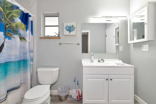 Baño blanco con aseo y lavamanos en Walk to the beach - Island Villa, en Siesta Key