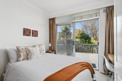 RAG03 - Balmoral Bliss - Spacious 2 Bedroom Beach Apartment في سيدني: غرفة نوم بسرير ونافذة كبيرة