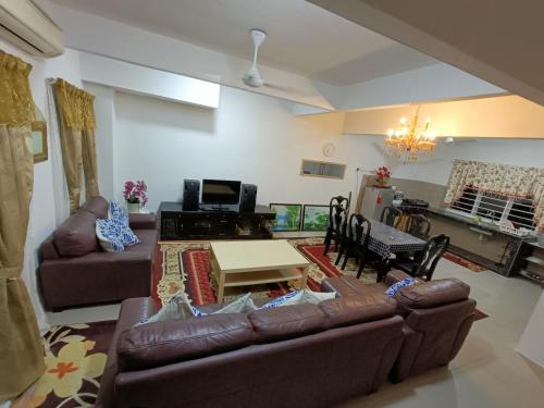 - un salon avec un canapé et une table dans l'établissement Homestay Kesang Sungai Rambai, à Kampong Sungai Rambai