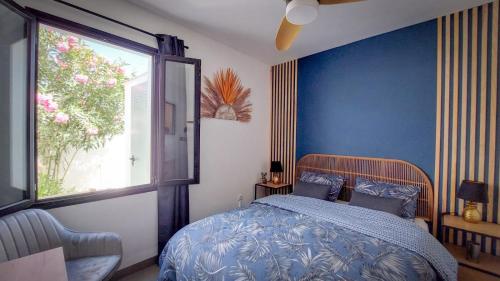 um quarto com uma cama com paredes azuis e uma janela em Villa Zephyr con piscina privada. em Gran Tarajal