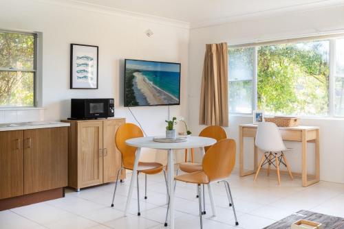 a kitchen and dining room with a table and chairs at Mindi's in Narrawallee