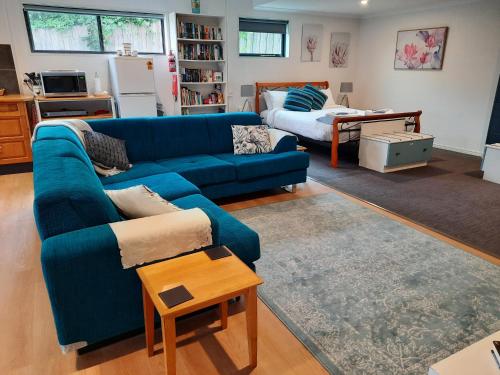 Beaconsfield的住宿－GOLDFIELDS STUDIO APARTMENT, Beaconsfield - Fully Self-contained, air-conditioning，客厅配有蓝色的沙发和桌子