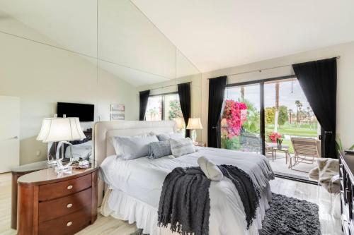 a bedroom with a bed and a large window at Paradise Point- Green View, Tennis, and Activity Club in Palm Desert