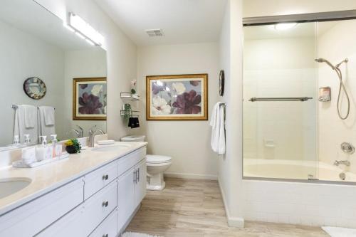 a white bathroom with a shower and a toilet at Paradise Point- Green View, Tennis, and Activity Club in Palm Desert