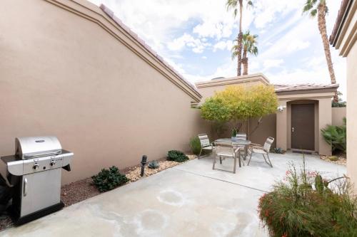 a patio with a grill and a table and chairs at Paradise Point- Green View, Tennis, and Activity Club in Palm Desert
