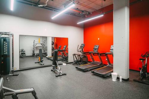 a gym with cardio equipment and red walls at NEW Luxury 1BR Penthouse Apt In Central Halifax in Halifax