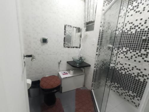 y baño con ducha, aseo y lavamanos. en Apartamento para até 05 pessoas no centro, en Teresópolis