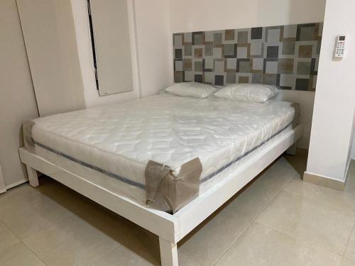 a bed in a room with a white mattress at Modern complet appartement met Balkon in Kralendijk