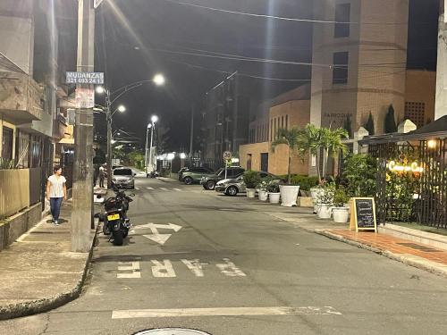 an empty city street at night with a motorcycle parked at Acogedor Apartaestudio Santa Fe in Medellín
