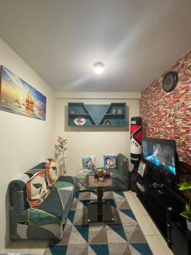 a living room with a couch and a tv at Kachada Condotel Urban Deca Home in Manila