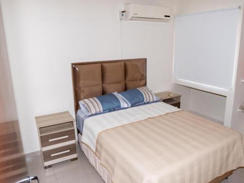 a bedroom with a large bed with a blue pillow at Casa Pinatar en condominio in Santa Cruz de la Sierra
