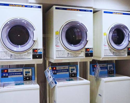 four washing machines are lined up in a store at Beagle Tokyo Hostel＆Apartments in Tokyo