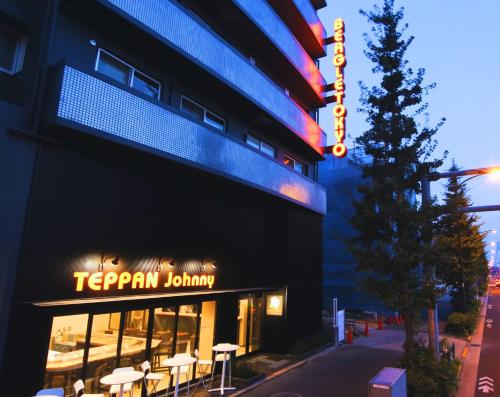 ein Restaurant mit einem Schild an der Seite eines Gebäudes in der Unterkunft Beagle Tokyo Hostel＆Apartments in Tokio