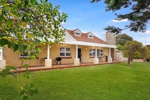 a house with a green lawn in front of it at Ashdene Busselton in Busselton