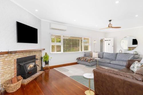 a living room with a couch and a fireplace at Ashdene Busselton in Busselton