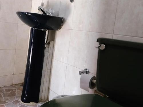 a bathroom with a black sink and a toilet at Sapiens house"la Gallita de roca" in Cali