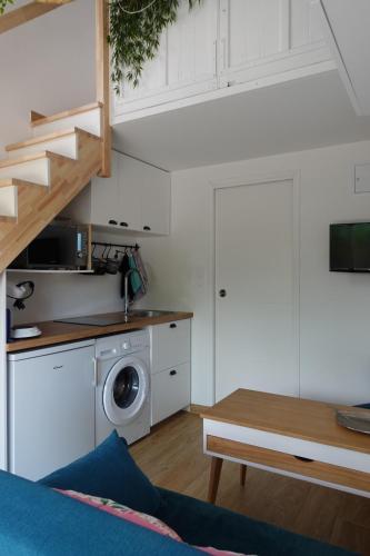 un salon avec un escalier et un lave-linge dans l'établissement *Tiny Jungle* / Plage, port et commerces à pied, à Sausset-les-Pins