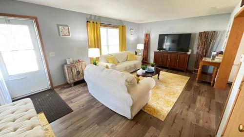 a living room with a white couch and a tv at Luxx Guest House in Milwaukee