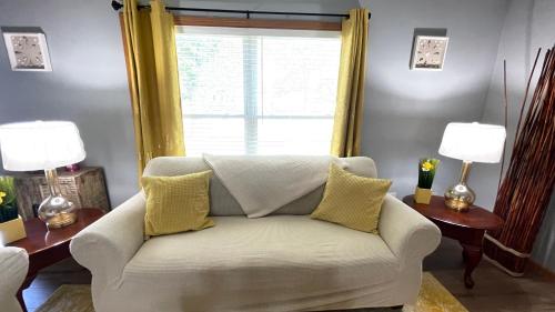 a living room with a white couch and a window at Luxx Guest House in Milwaukee