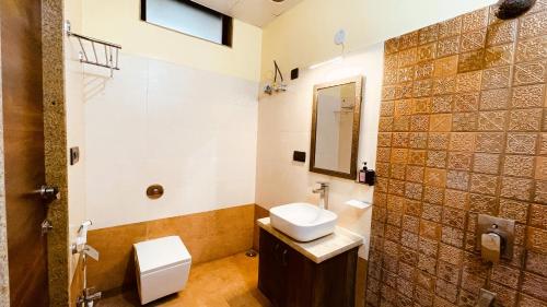 HILLCREST PALACE في أودايبور: حمام مع حوض ومرحاض ومرآة
