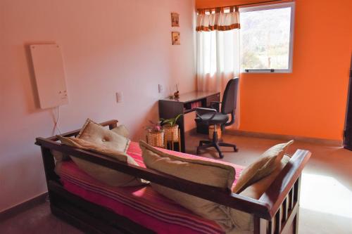 Cette chambre comprend un lit avec des oreillers et un bureau. dans l'établissement CASITA MUNAY - Cabaña en Huacalera - Quebrada de Humahuaca - Jujuy, à Huacalera