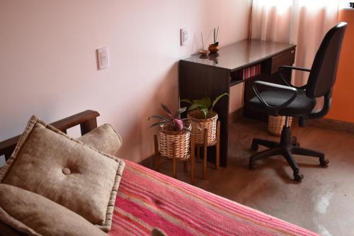 - une chambre avec un bureau, une chaise et un lit dans l'établissement CASITA MUNAY - Cabaña en Huacalera - Quebrada de Humahuaca - Jujuy, à Huacalera