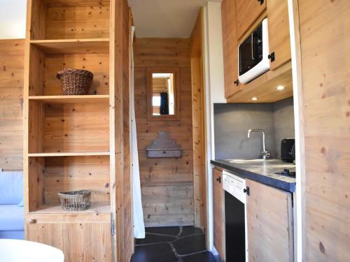 a kitchen in a tiny house with wooden walls at Studio/Coin montagne - 4 pers, proche pistes & commerces, balcon, parking, WIFI - Méribel - FR-1-180-599 in Les Allues