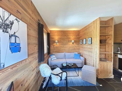 - un salon avec un canapé blanc et des murs en bois dans l'établissement Studio/Coin montagne - 4 pers, proche pistes & commerces, balcon, parking, WIFI - Méribel - FR-1-180-599, à Les Allues
