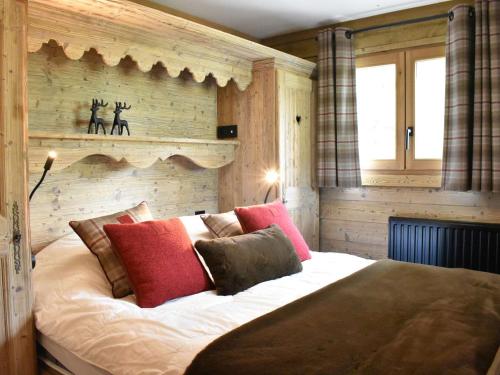 ein Schlafzimmer mit einem großen Bett mit roten und braunen Kissen in der Unterkunft Appartement 3 pièces à Méribel Village avec WIFI et parking privatif - FR-1-180-600 in Les Allues
