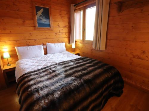 ein Schlafzimmer mit einem Bett in einem Blockhaus in der Unterkunft Appartement Tignes, 5 pièces, 8 personnes - FR-1-502-531 in Tignes