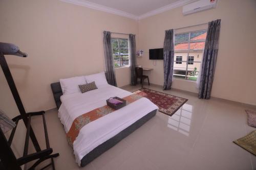a bedroom with a bed and a television in it at Bee Good Chalet in Yan