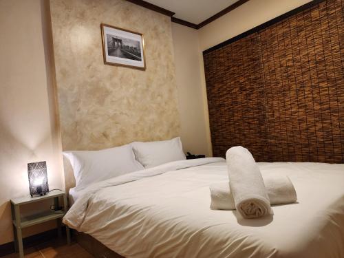 ein Schlafzimmer mit einem weißen Bett und Handtüchern darauf in der Unterkunft The Travellers House - Pet Friendly Accommodation in Bangkok