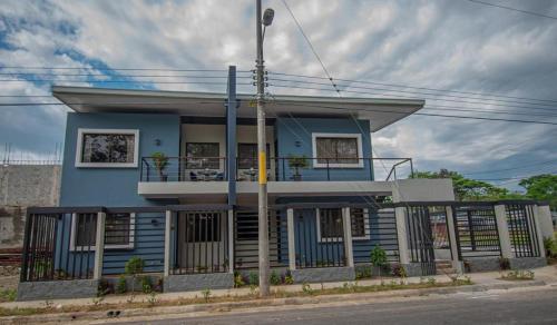 a blue house with a balcony on a street at Apartamentos Bukare in Quepos