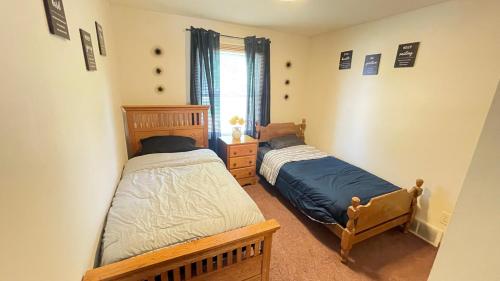 a bedroom with two beds and a window at Luxx Guest House in Milwaukee