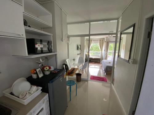a kitchen with white cabinets and a living room at Private room hosted by Boyce 401 in Chiang Mai