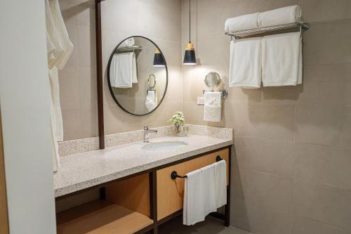 uma casa de banho com lavatório, espelho e toalhas em Mandarin Nest Boracay em Boracay